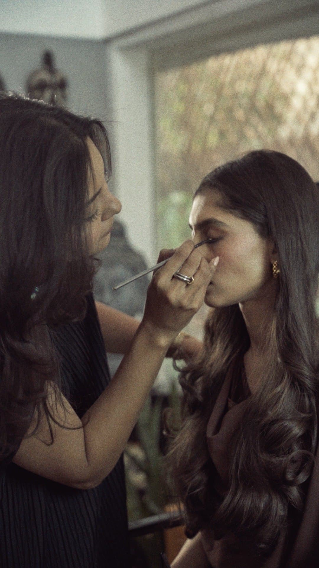 Shafaq working on a client's eye makeup in daylight
